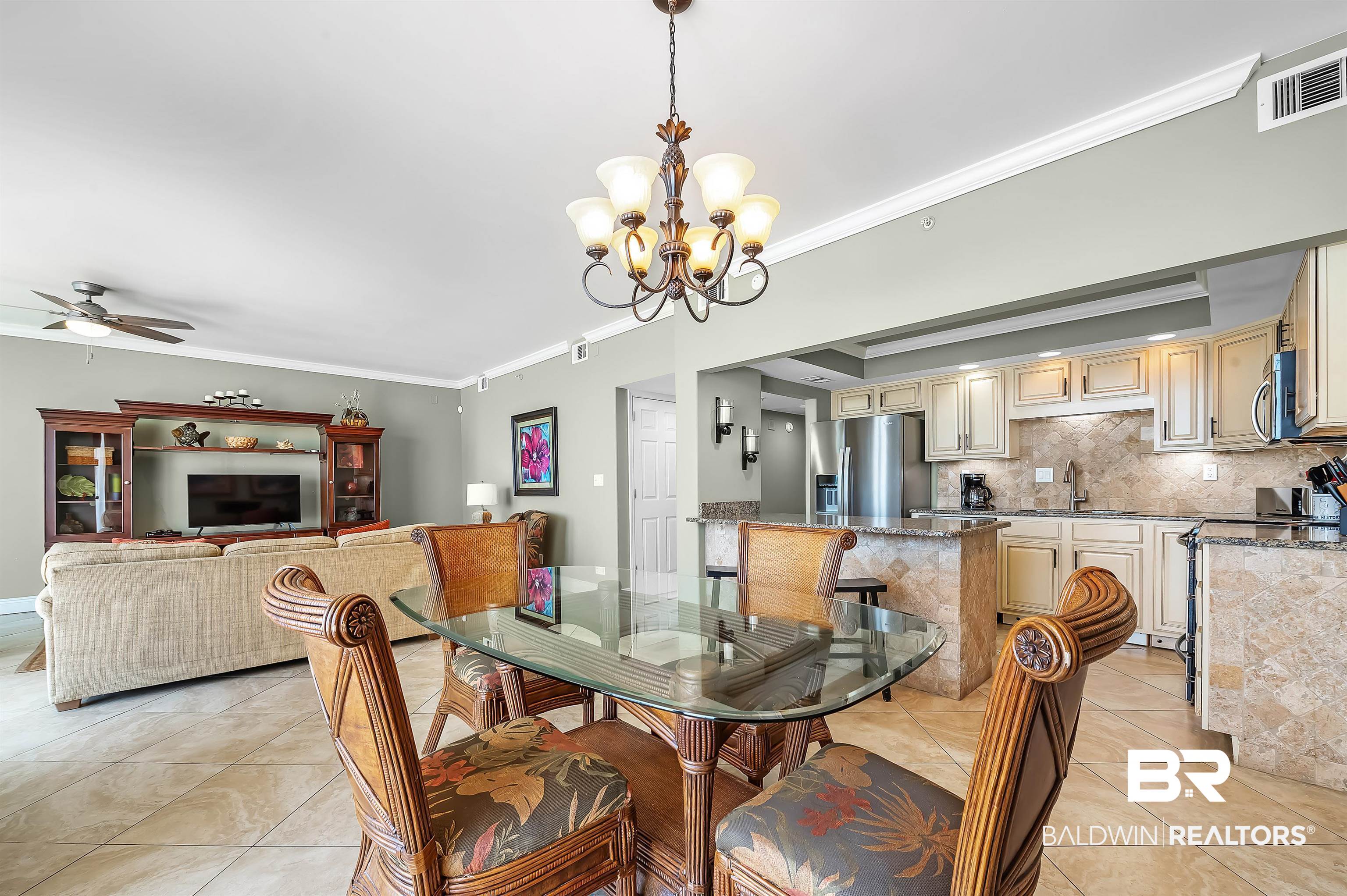 16287 Perdido Key Drive, Unit 105 Pensacola, FL 32507 - Photo 14 of 66 Open-concept living area featuring a kitchen with light-toned cabinetry, stainless steel appliances, and stone countertops, extending into a dining space with a glass-top table