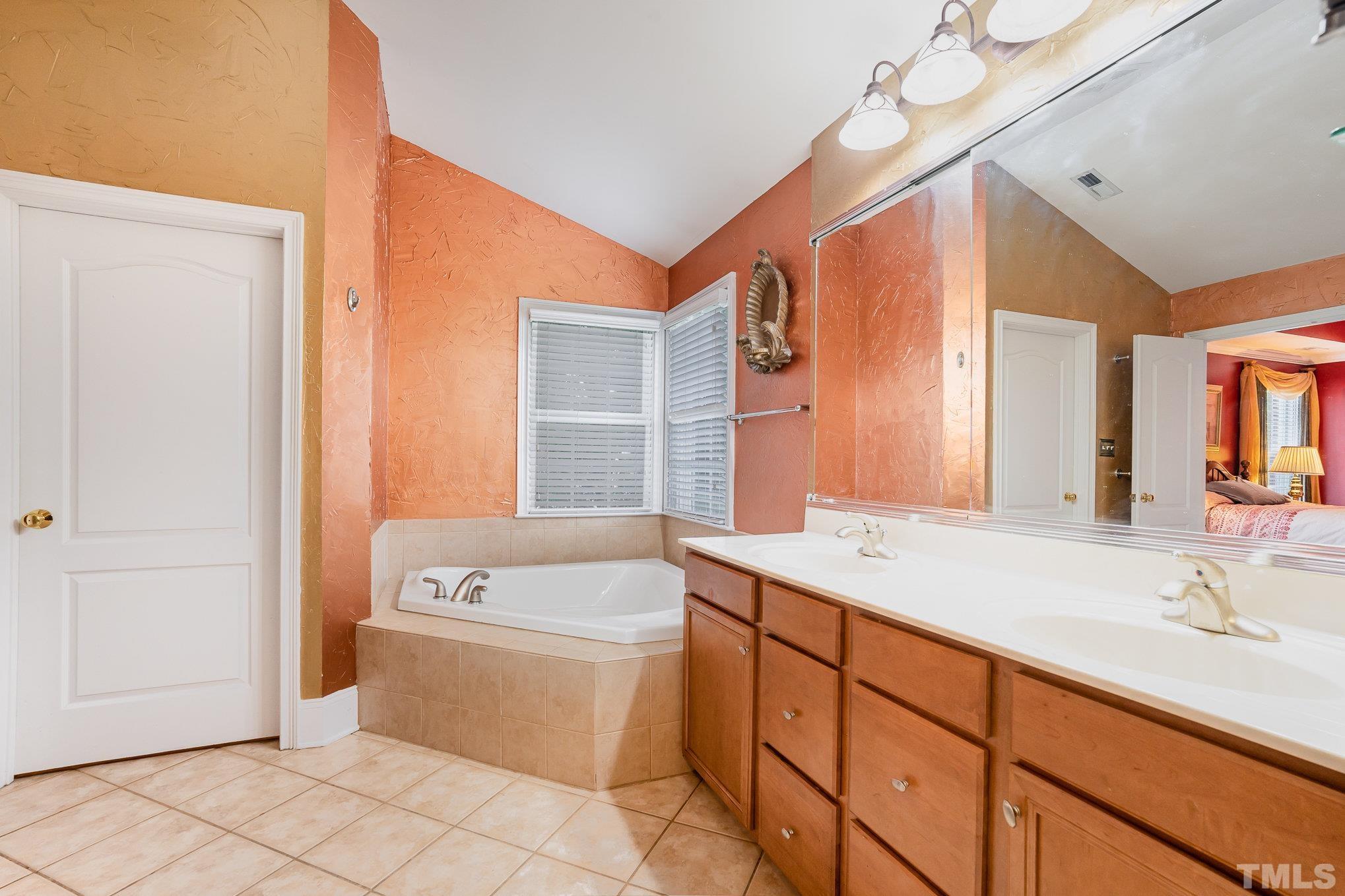 9300 Palm Bay Circle Raleigh, NC 27617 - Photo 13 of 30 a bathroom with a sink a vanity and a bathtub