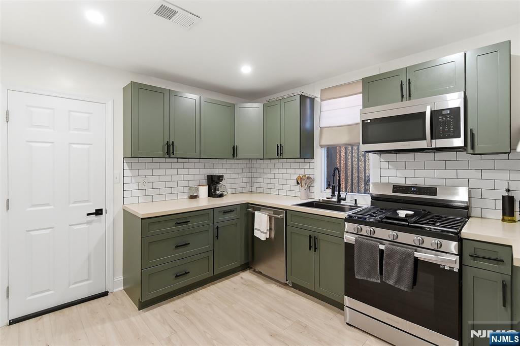 22 8th Avenue Newark, NJ 07104 - Photo 8 of 26 a kitchen with stainless steel appliances granite countertop a stove and a sink
