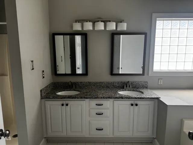 a bathroom with a granite countertop sink and a mirror