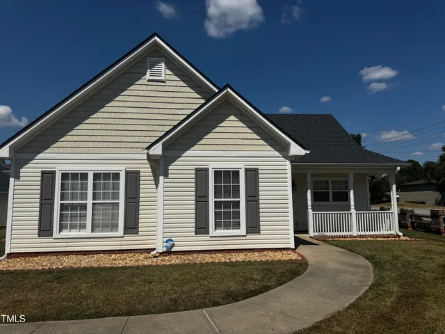 a front view of a house with a yard and seating space