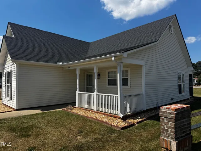 a view of a house with backyard and porch