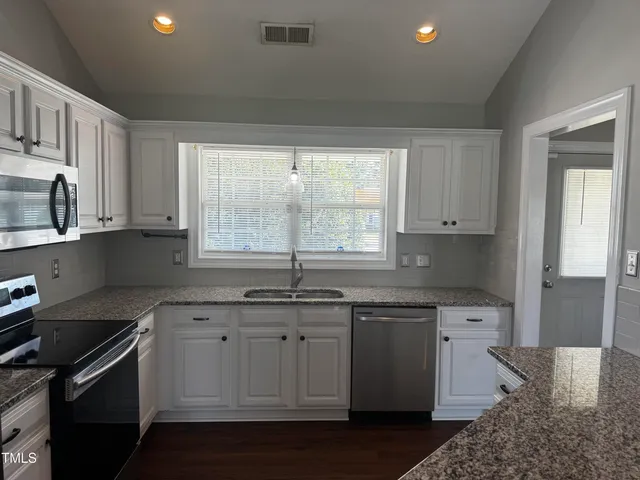 a kitchen with a sink stove and cabinets