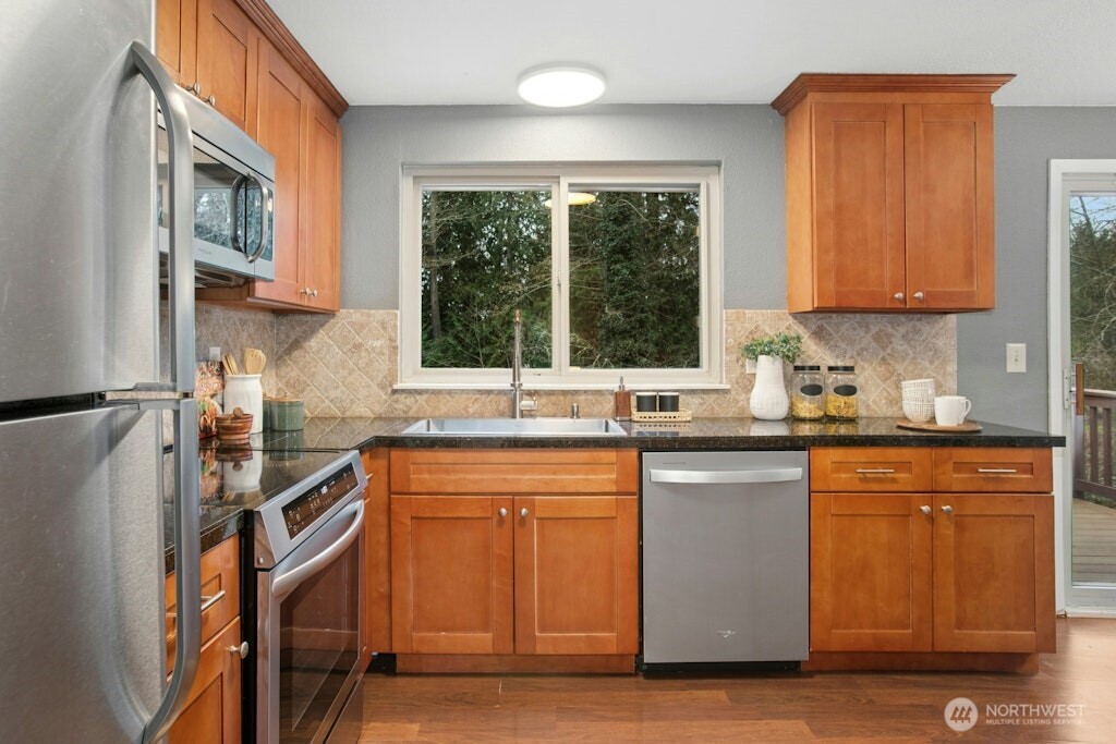 1104 204th Place Southeast Bothell, WA 98012 - Photo 6 of 30 a kitchen with stainless steel appliances granite countertop a sink a stove a refrigerator cabinets and a window