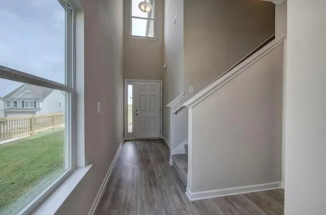 a view of a hallway with wooden floor and staircase