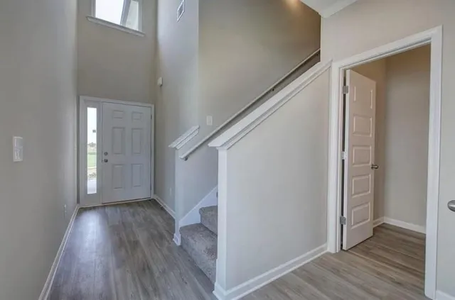 a view of a hallway with wooden floor and staircase