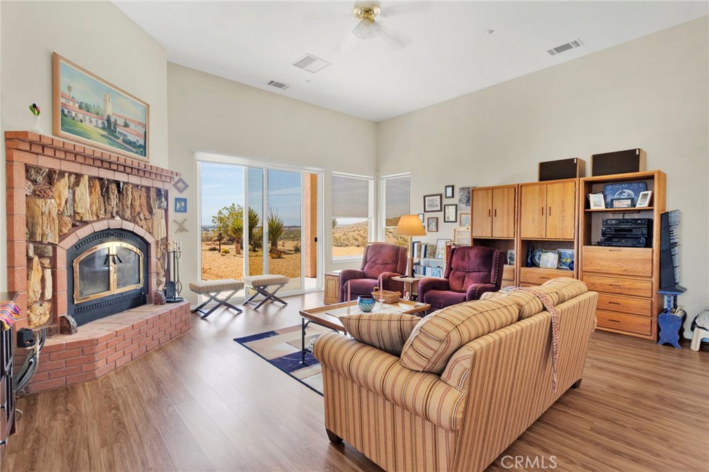 16222 Wild Road Helendale, CA 92342 - Photo 20 of 75 a living room with furniture a fireplace and a floor to ceiling window