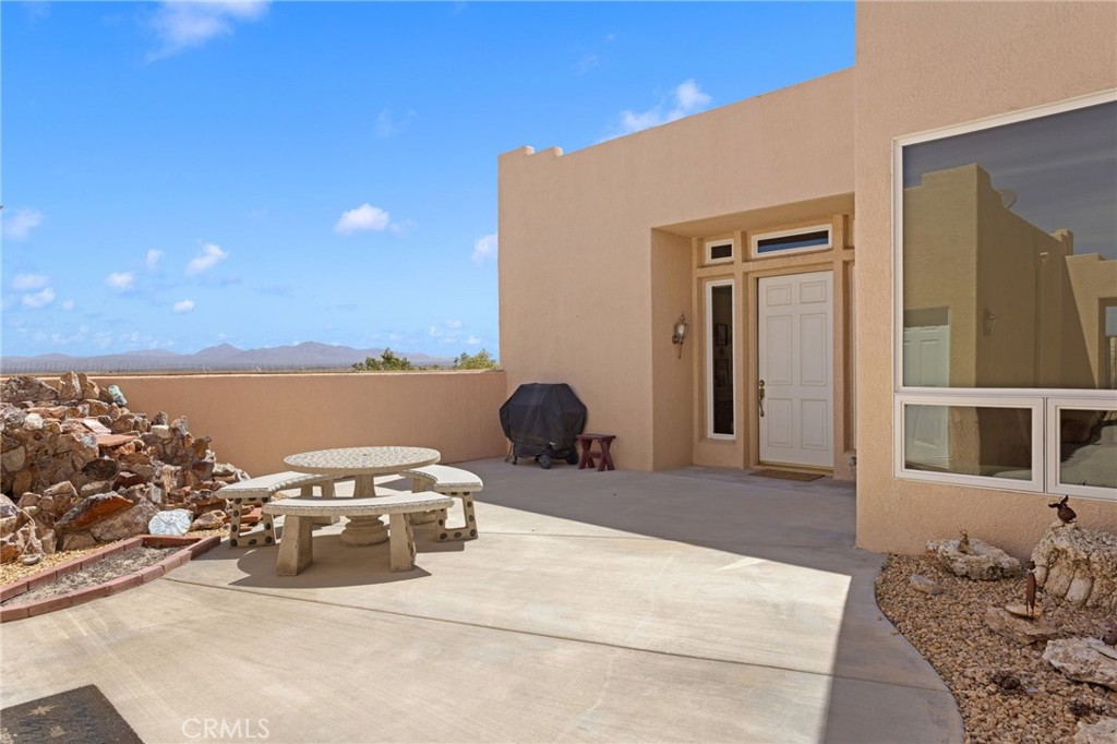 16222 Wild Road Helendale, CA 92342 - Photo 5 of 75 a living room with furniture a flat screen tv and a floor to ceiling window
