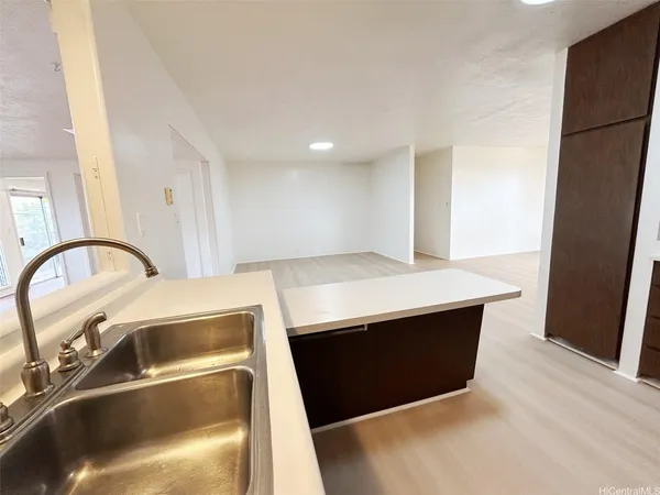 a close view of sink and dishwasher with kitchen island