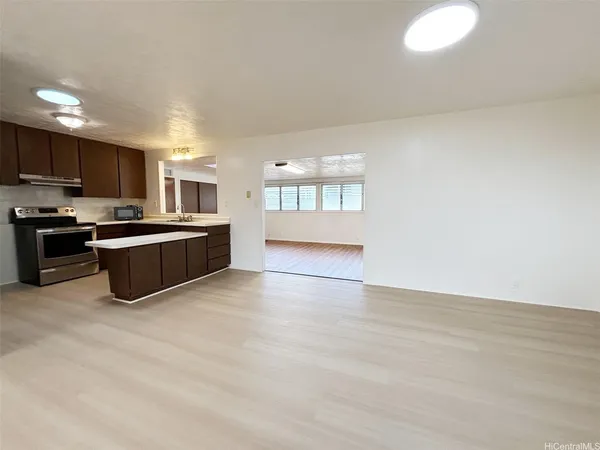 a view of kitchen with kitchen island a sink wooden floor and black appliances