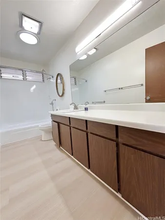 a spacious bathroom with a sink a mirror and a clock on the wall