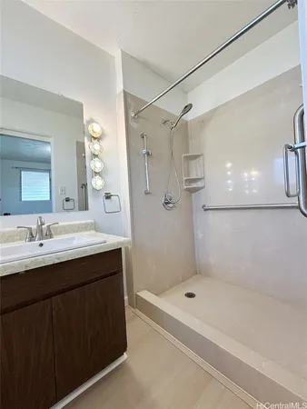 a bathroom with a shower sink vanity and mirror
