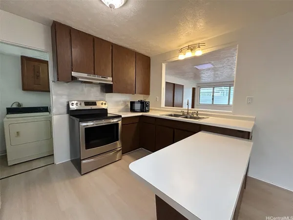 a kitchen with stainless steel appliances a sink stove and microwave