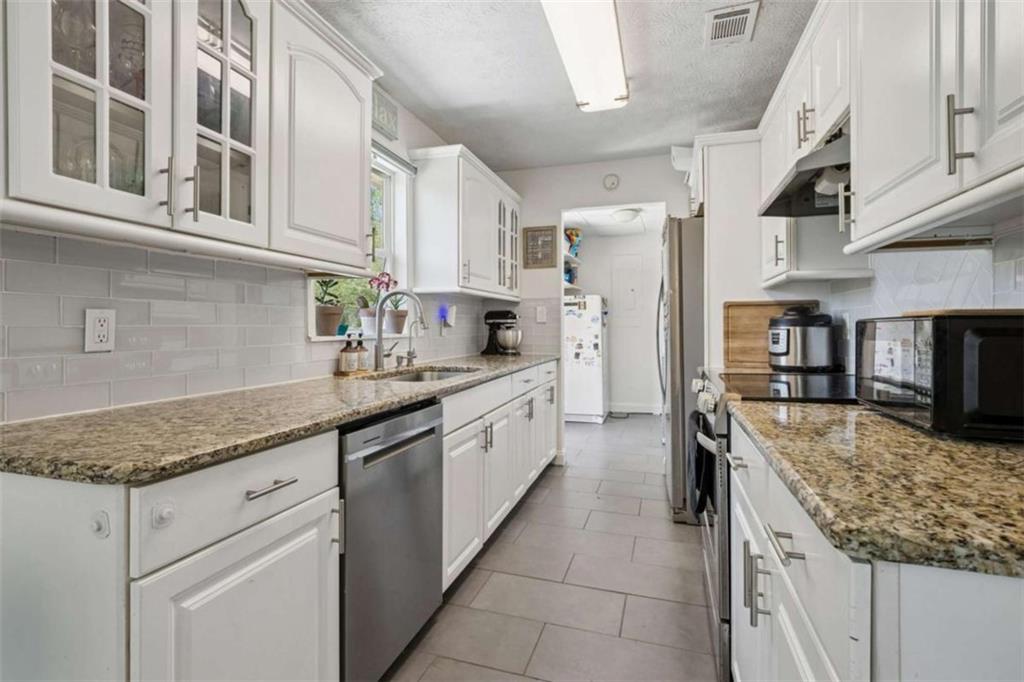 795 Tanner Road Dacula, GA 30019 - Photo 20 of 47 a kitchen with stainless steel appliances granite countertop a sink stove and cabinets