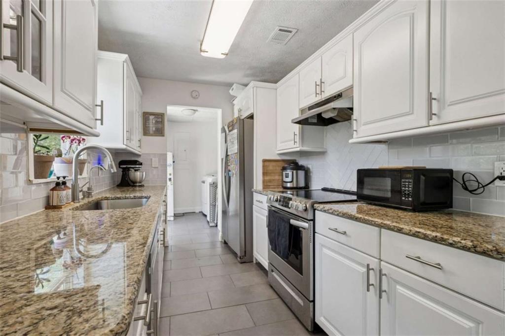 795 Tanner Road Dacula, GA 30019 - Photo 21 of 47 a kitchen with stainless steel appliances granite countertop a stove a sink and a refrigerator