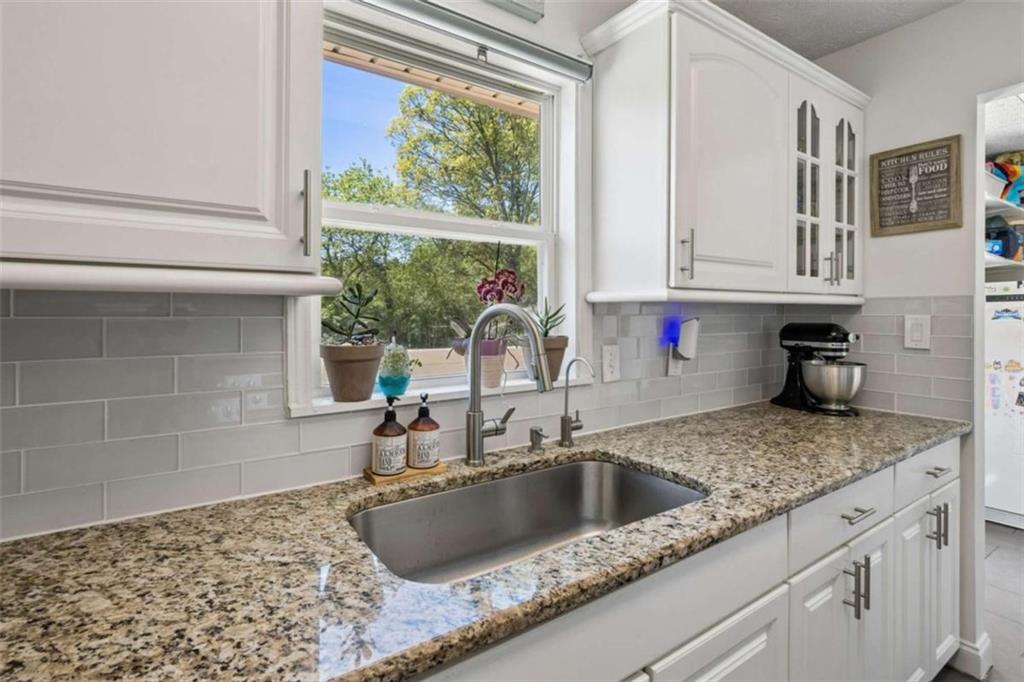 795 Tanner Road Dacula, GA 30019 - Photo 23 of 47 a kitchen with granite countertop a sink and a window
