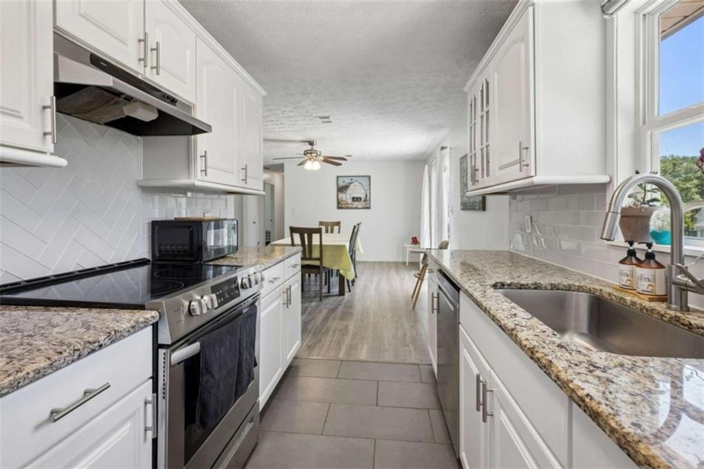 795 Tanner Road Dacula, GA 30019 - Photo 24 of 47 a kitchen with stainless steel appliances granite countertop a sink a stove and a refrigerator