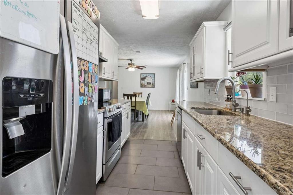795 Tanner Road Dacula, GA 30019 - Photo 25 of 47 a large kitchen with stainless steel appliances granite countertop a sink and a refrigerator