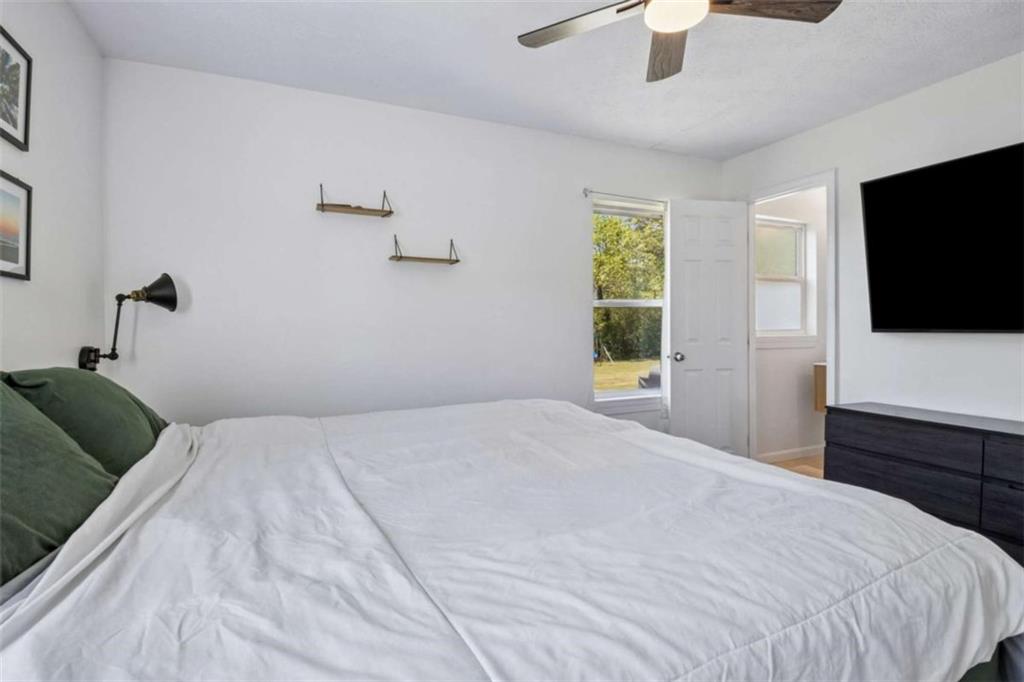 795 Tanner Road Dacula, GA 30019 - Photo 30 of 47 a bedroom with a large bed and a flat screen tv