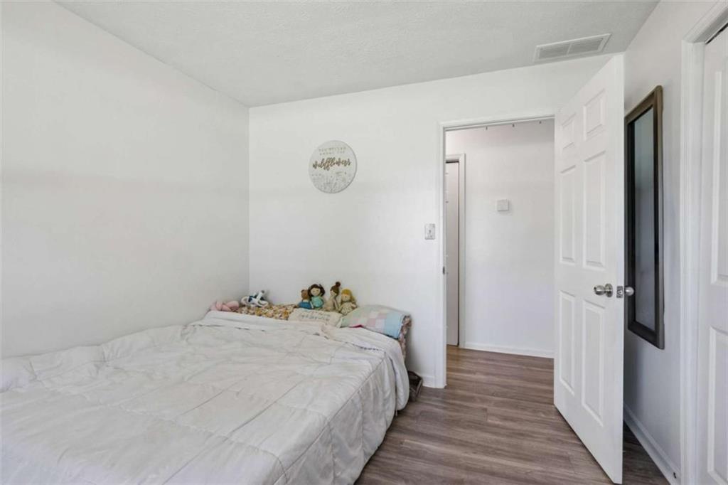 795 Tanner Road Dacula, GA 30019 - Photo 40 of 47 a bedroom with a bed and wooden floor