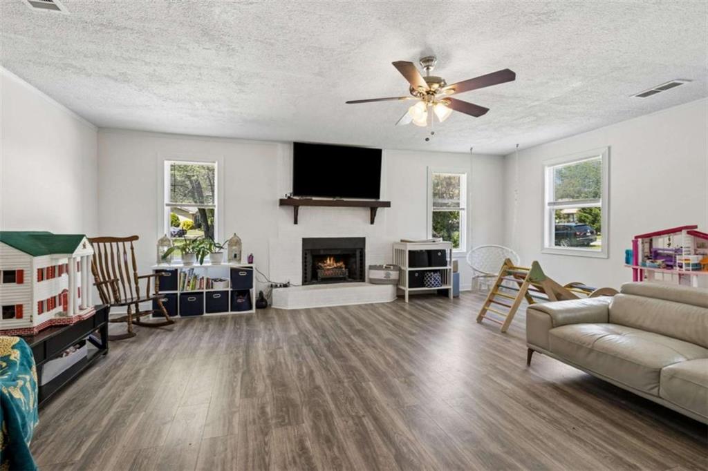 795 Tanner Road Dacula, GA 30019 - Photo 9 of 47 a living room with furniture a fireplace and a flat screen tv