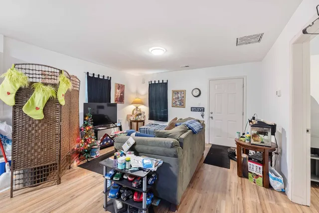 a living room with furniture and a flat screen tv with wooden floor