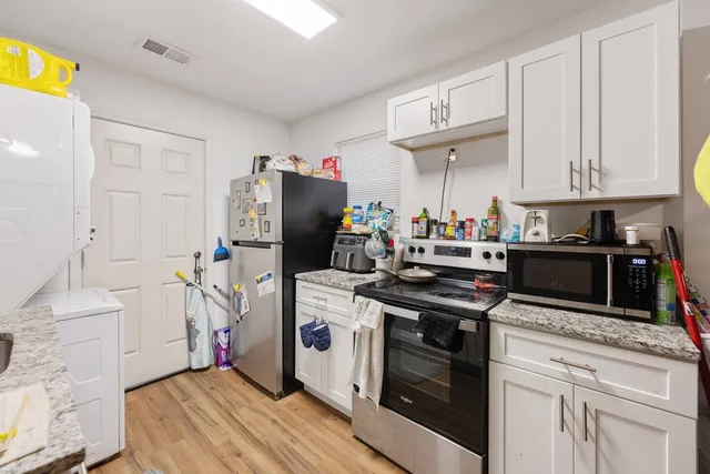 a kitchen with stainless steel appliances granite countertop a stove a refrigerator and a cabinets