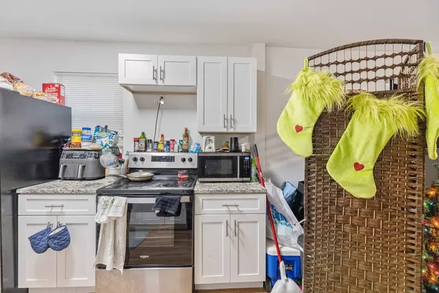 a kitchen with a white stove top oven and cabinets