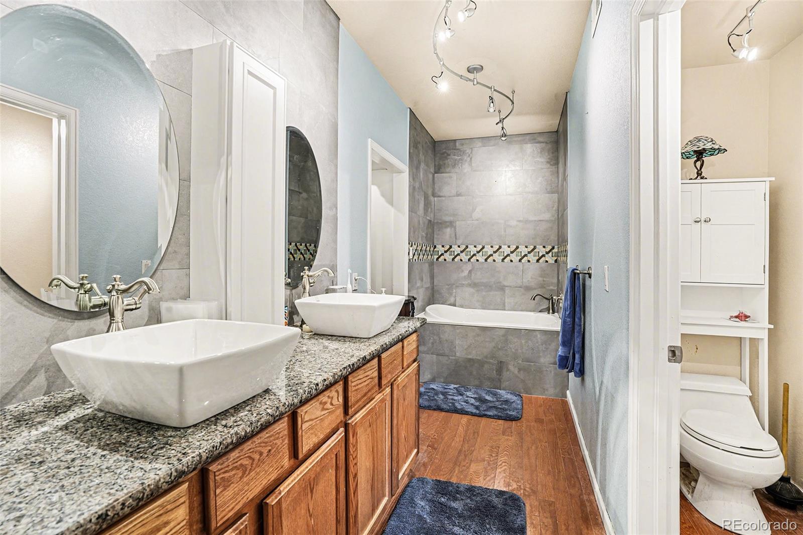 6293 Kilmer Loop, Unit 101 Golden, CO 80403 - Photo 12 of 19 a bathroom with a granite countertop sink and a mirror