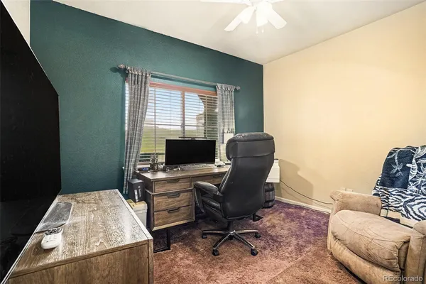 a view of a workspace with furniture and a window