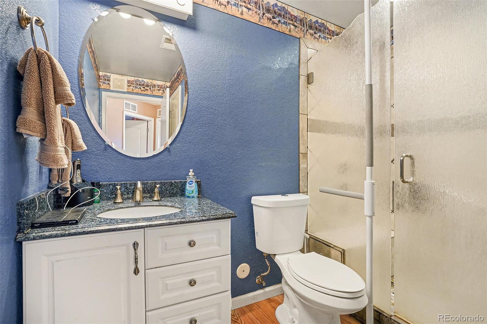 6293 Kilmer Loop, Unit 101 Golden, CO 80403 - Photo 14 of 17 a bathroom with a toilet sink vanity and mirror