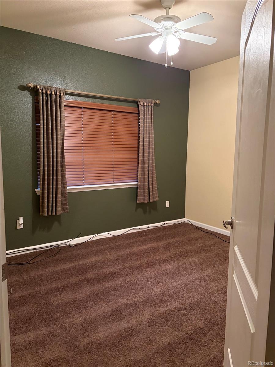 6293 Kilmer Loop, Unit 101 Golden, CO 80403 - Photo 14 of 19 a view of an empty room with window and chandelier fan
