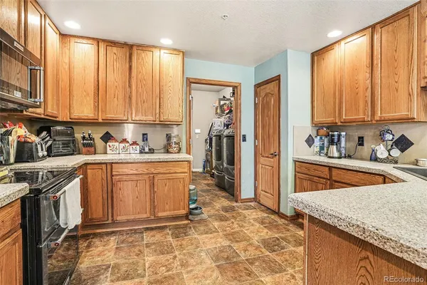 a kitchen with stainless steel appliances granite countertop a refrigerator a stove and white cabinets