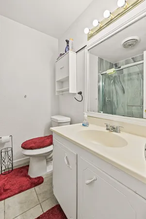a bathroom with a sink vanity mirror and toilet