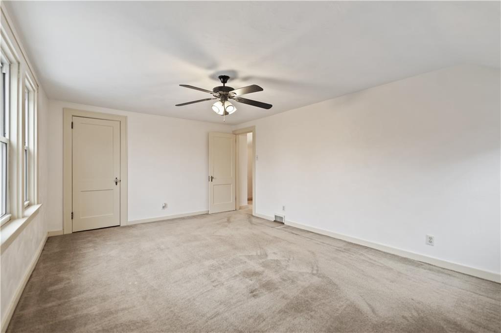 230 West Marigold Street Homestead, PA 15120 - Photo 15 of 50 an empty room with a chandelier fan and windows