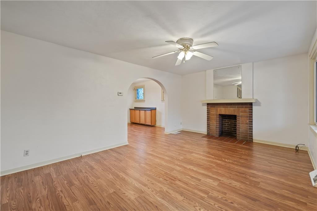 230 West Marigold Street Homestead, PA 15120 - Photo 6 of 50 an empty room with wooden floor fan and windows
