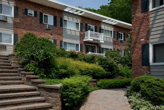 a front view of a house with plants and trees