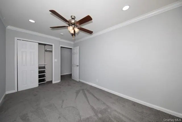 an empty room with closet and ceiling fan