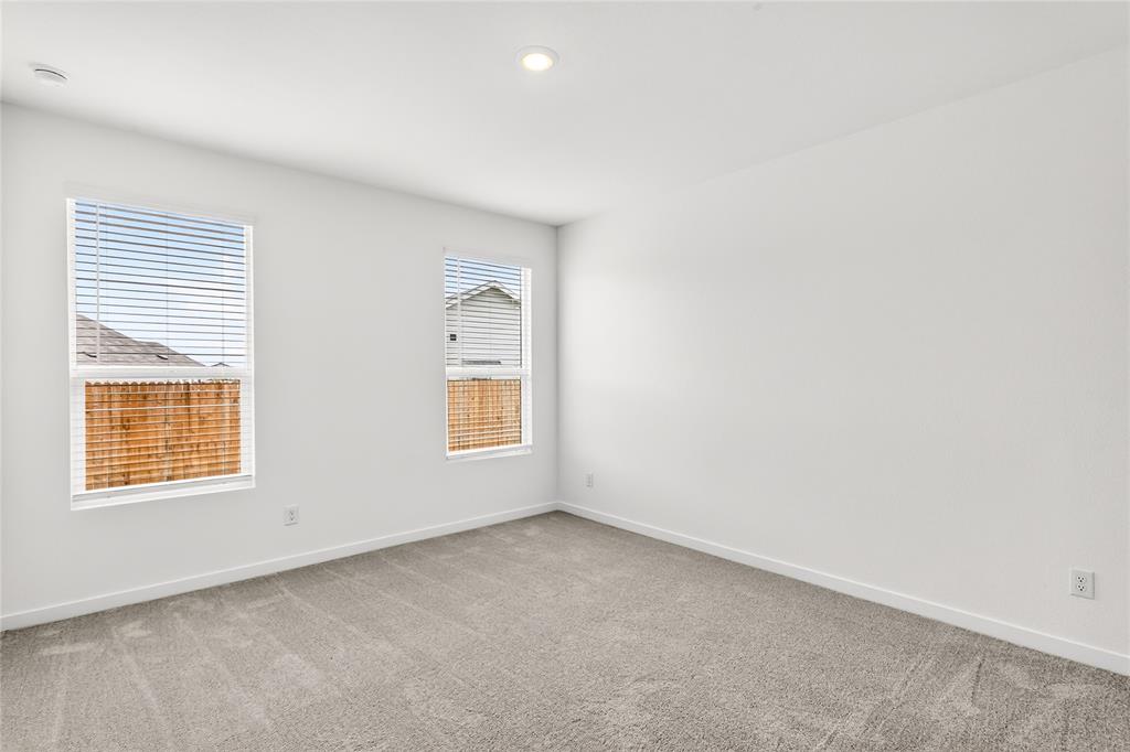656 Waymaker Way Princeton, TX 75407 - Photo 6 of 40 Bright room featuring two windows with horizontal blinds, neutral-toned carpeting, white walls, and a recessed ceiling light