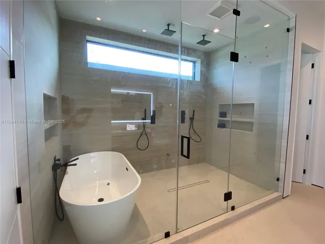 a bathroom with a white bath tub a shower and a sink