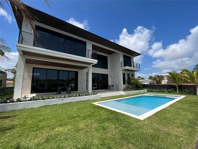 a view of a house with a swimming pool and a yard
