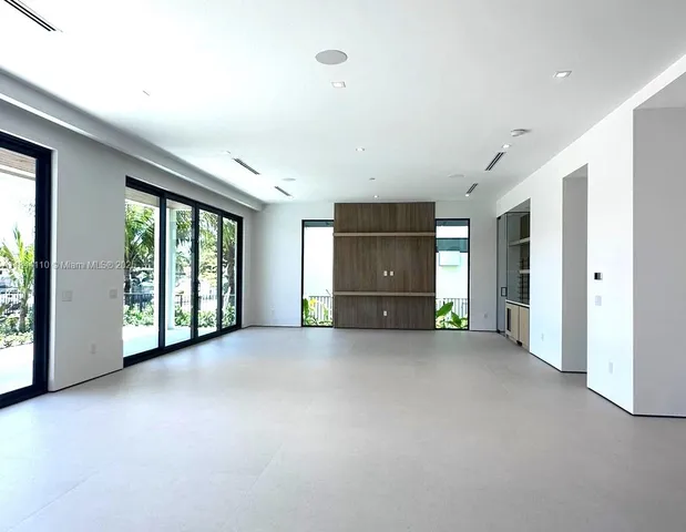 a view of an empty room with a fireplace and a large window