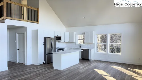 a kitchen with stainless steel appliances a refrigerator sink and cabinets