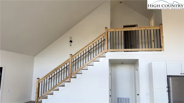 a view of staircase with lots of frames on wall and a window