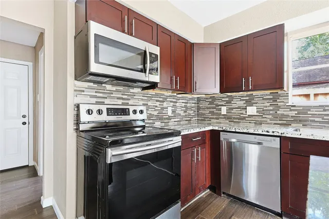 a kitchen with stainless steel appliances granite countertop a refrigerator and a sink