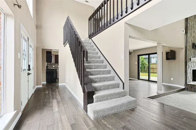 a view of staircase with lots of frames on wall and wooden floor