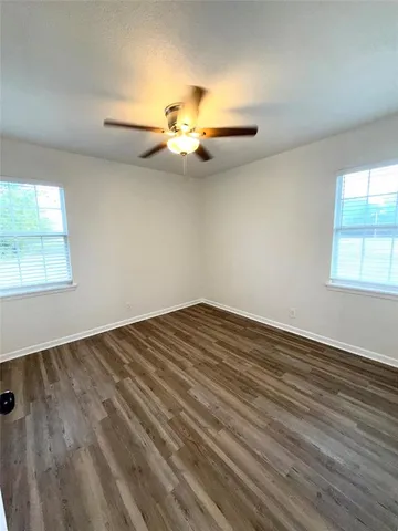 a view of a room with wooden floor and fan