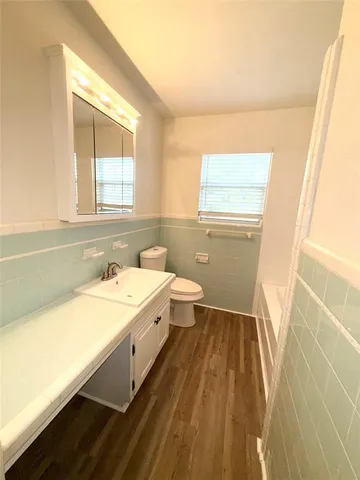 a bathroom with a sink a bathtub and a window
