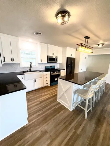 a kitchen with stainless steel appliances a stove a sink dishwasher and a refrigerator