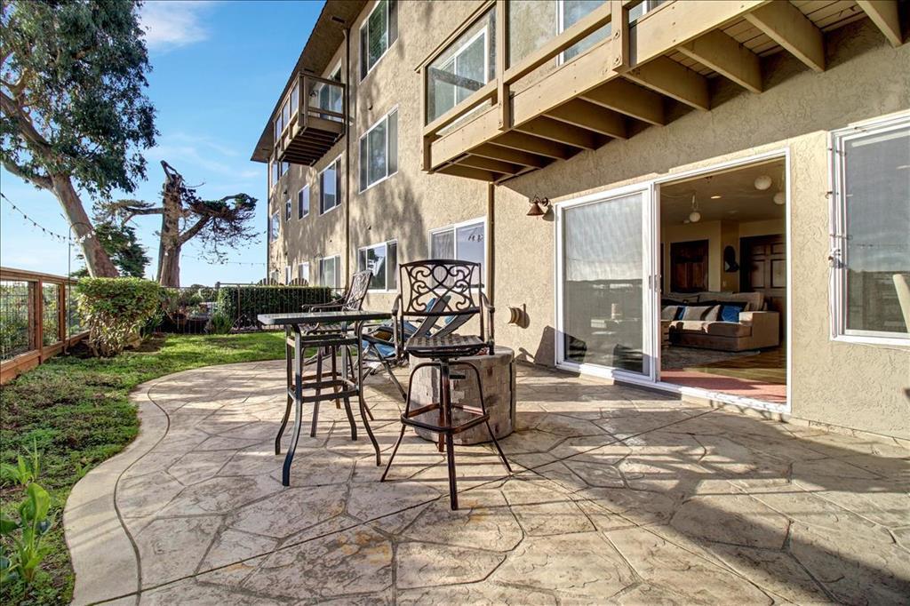 4820 Opal Cliff Drive, Unit 102 Capitola, CA 95010 - Photo 3 of 38 a view of a patio with a table and chairs and potted plants